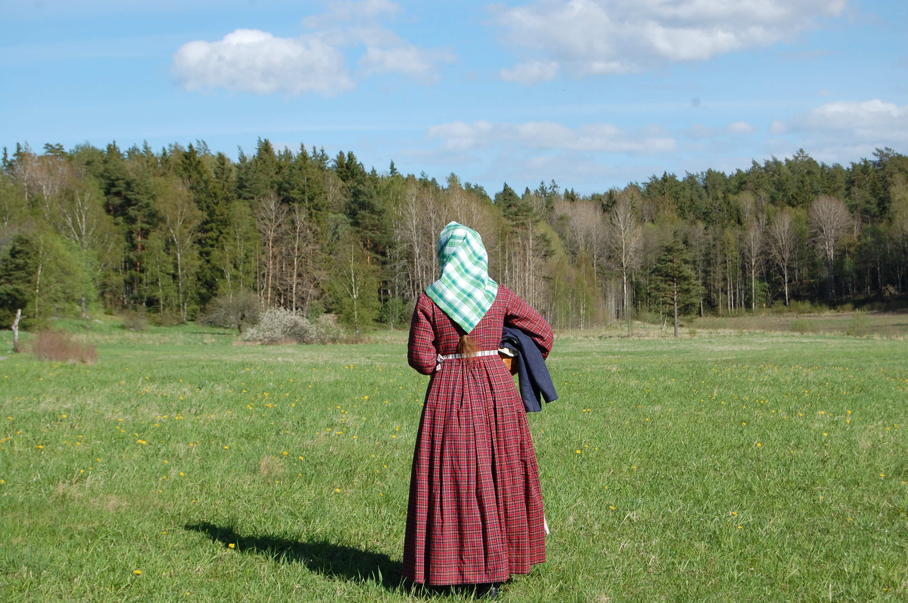 Bakifrån i rutig 1850-talsklänning och sjalett