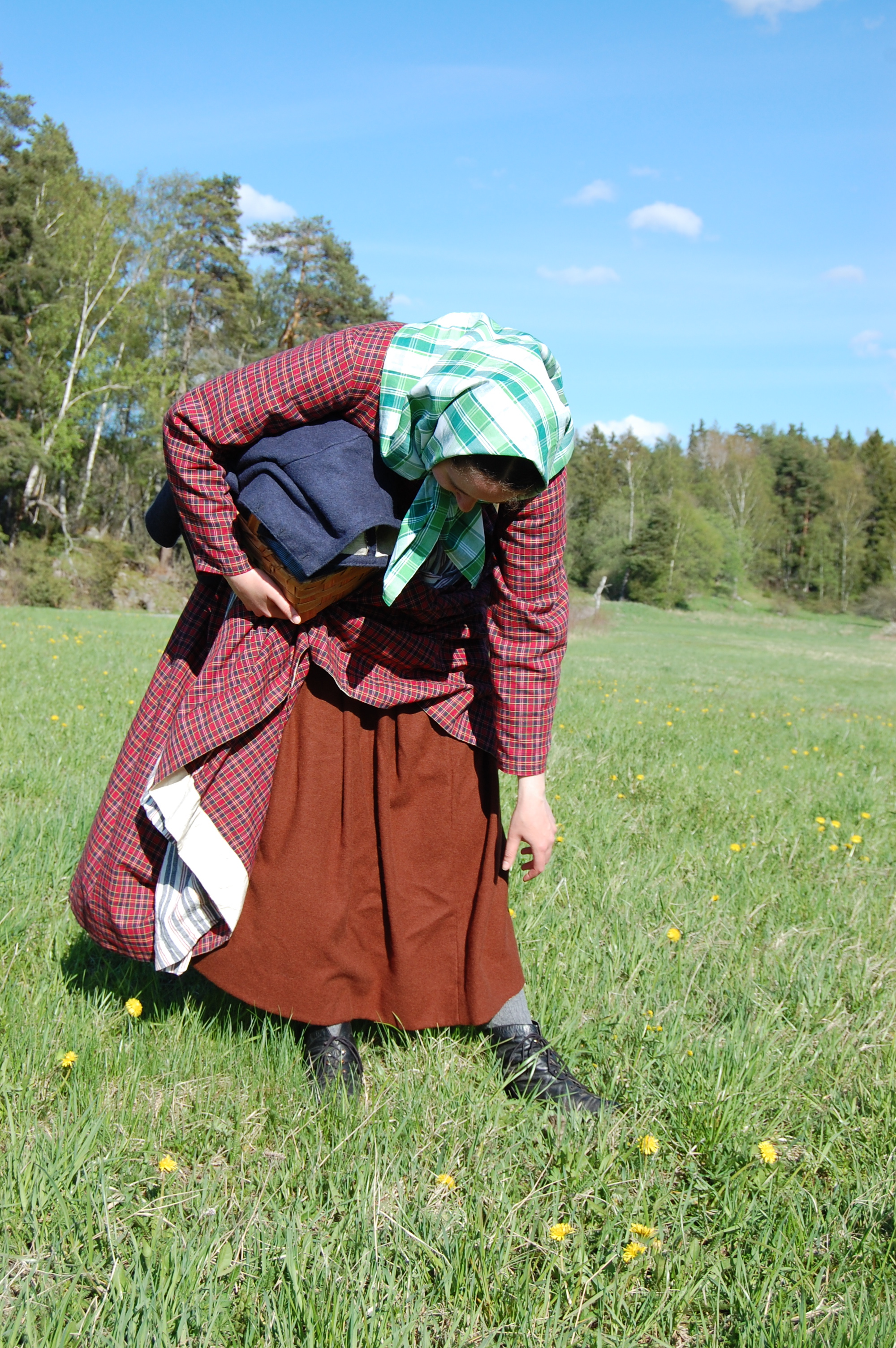 I brun ylleunderkjol, rutig 1850-talsklänning och sjalett