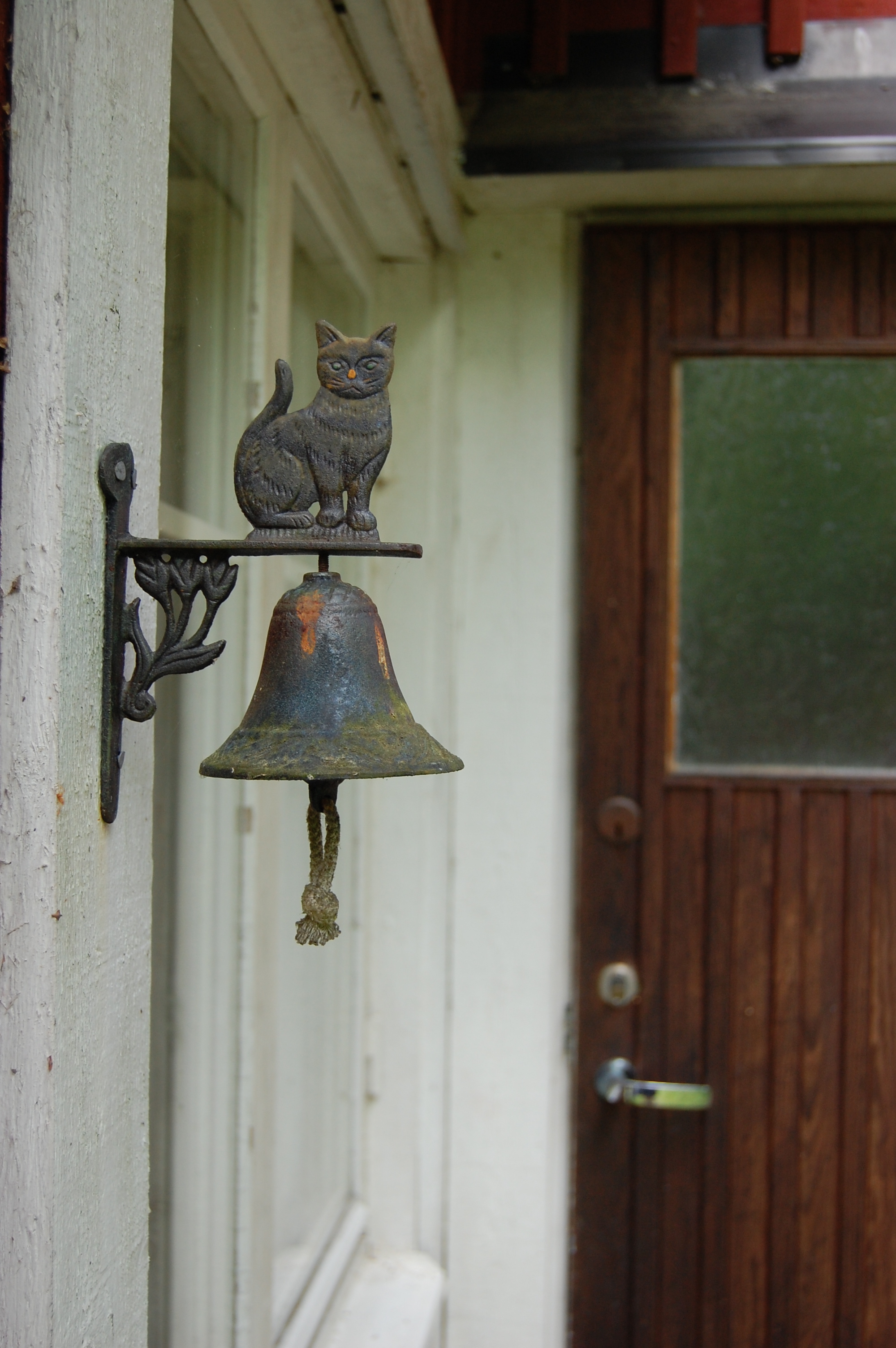 Gammal ringklocka i järn med kattmotiv